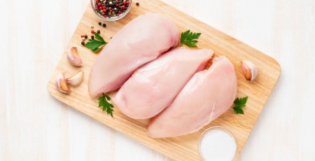 raw chicken breasts on a cutting board